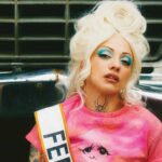 Mon Laferte posing in red during the Femme Fatale era promotional campaign