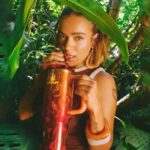 Karol G in the jungle with a Stanley