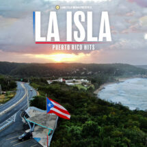 Puerto Rico flag waving at a coastal overlook with a winding road and forested hills at sunset