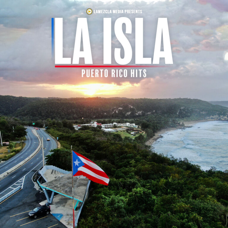 Puerto Rico flag waving at a coastal overlook with a winding road and forested hills at sunset